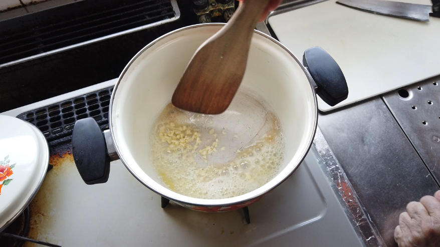 【オニオンスープレシピ】２．ほうろう鍋にバターを入れて熱し、にんにくを入れて香りを出します。